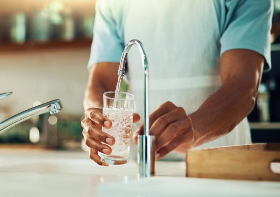 Person pouring treated tap water for household or community use
